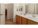 Double sink bathroom with neutral wood cabinets and flooring at 14623 W Hearn Rd, Surprise, AZ 85379