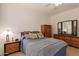 Bright bedroom with a double bed, wooden furniture, and mirrored dresser at 14623 W Hearn Rd, Surprise, AZ 85379