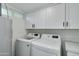 Laundry room with washer, dryer and white cabinets at 8247 E Devonshire Ave, Scottsdale, AZ 85251
