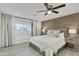 Bright bedroom with a king-size bed, window seat, and ceiling fan at 8247 E Devonshire Ave, Scottsdale, AZ 85251