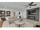 Bright and airy living room with a modern fireplace and large TV at 8247 E Devonshire Ave, Scottsdale, AZ 85251