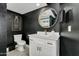 Bathroom with white vanity, black walls, and a round mirror at 8247 E Devonshire Ave, Scottsdale, AZ 85251