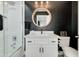 Modern bathroom with white vanity, black walls, and a large mirror at 8247 E Devonshire Ave, Scottsdale, AZ 85251