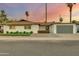Charming single story home with a modern gray garage door at 8247 E Devonshire Ave, Scottsdale, AZ 85251