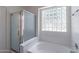 Bathroom with shower, bathtub, and a large block window for natural light at 9859 W Potter Dr, Peoria, AZ 85382