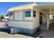 Side view of a tan mobile home with stairs and small yard at 7300 N 51St Ave # 160, Glendale, AZ 85301