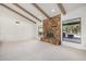 Living area featuring a stone fireplace, carpeted floors, and windows offering backyard views at 27221 N 71St Pl, Scottsdale, AZ 85266