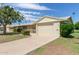 Ranch-style home with attached garage and well-manicured lawn at 10318 W Desert Forest Cir, Sun City, AZ 85351