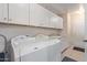 Bright laundry room with washer, dryer, and ample cabinetry at 10318 W Desert Forest Cir, Sun City, AZ 85351