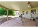 Covered patio with table and chairs, overlooking backyard at 10318 W Desert Forest Cir, Sun City, AZ 85351