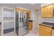 Kitchen area with stainless steel refrigerator and laundry area at 10318 W Desert Forest Cir, Sun City, AZ 85351