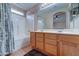 Bathroom with double sinks, wood cabinets, and a bathtub at 3128 E Millbrae Ln, Gilbert, AZ 85234