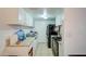 Long kitchen with white cabinets and black appliances at 6842 W Devonshire Ave, Phoenix, AZ 85033