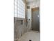 Bathroom with marble tile, a walk-in shower, and a glass-block window at 10512 E Cortez Dr, Scottsdale, AZ 85259