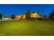 Expansive backyard with artificial turf, pool, and well-lit landscaping at night at 10512 E Cortez Dr, Scottsdale, AZ 85259