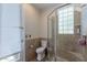 Bathroom with toilet, shower, and glass block window at 10512 E Cortez Dr, Scottsdale, AZ 85259