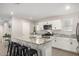 Modern kitchen with white cabinets, granite countertops, and island with seating at 16256 W La Ventilla Way, Goodyear, AZ 85338