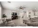 Spacious living room with gray sectional sofa, hardwood floors, and a staircase at 16256 W La Ventilla Way, Goodyear, AZ 85338