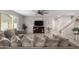 Bright living room features comfy gray sectional sofa and a large TV at 16256 W La Ventilla Way, Goodyear, AZ 85338