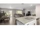 Kitchen island with granite countertop and stainless steel sink overlooks living room at 16256 W La Ventilla Way, Goodyear, AZ 85338
