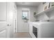 Bright laundry room with washer, dryer, and overhead shelving at 16256 W La Ventilla Way, Goodyear, AZ 85338