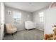 Bedroom featuring a crib, armchair, and plenty of natural light at 16256 W La Ventilla Way, Goodyear, AZ 85338