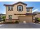 Two-story house with beige stucco, brown accents, and a two-car garage at 16256 W La Ventilla Way, Goodyear, AZ 85338