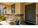 Covered front porch with a bench and potted plants at 16256 W La Ventilla Way, Goodyear, AZ 85338