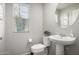 Clean bathroom with pedestal sink and white fixtures at 16256 W La Ventilla Way, Goodyear, AZ 85338