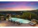 Luxury infinity pool with city views and lounge chairs at 10719 E Rimrock Dr, Scottsdale, AZ 85255