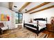 Bedroom with wooden bed frame, hardwood floors and large window at 10719 E Rimrock Dr, Scottsdale, AZ 85255