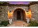 Arched entryway with stone facade and wooden door at 10719 E Rimrock Dr, Scottsdale, AZ 85255