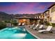 Resort-style pool area with outdoor fireplace and seating at 10719 E Rimrock Dr, Scottsdale, AZ 85255