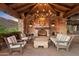 Stone fireplace with seating area under wood pergola at 10719 E Rimrock Dr, Scottsdale, AZ 85255