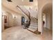 Elegant curved staircase with wrought iron railing and stone flooring at 10719 E Rimrock Dr, Scottsdale, AZ 85255