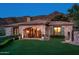 Stone house exterior with manicured lawn, mountain views at dusk at 10719 E Rimrock Dr, Scottsdale, AZ 85255