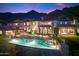 Luxury pool and patio area with mountain views at night at 10719 E Rimrock Dr, Scottsdale, AZ 85255