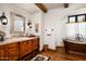 Bathroom with copper tub, wooden vanity, and hardwood floor at 10719 E Rimrock Dr, Scottsdale, AZ 85255