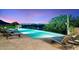 Infinity pool overlooking city lights at dusk at 10719 E Rimrock Dr, Scottsdale, AZ 85255