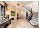 Grand staircase with wrought iron railing and patterned carpeting at 10719 E Rimrock Dr, Scottsdale, AZ 85255