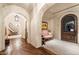 Long hallway with hardwood floors, arched doorways and a staircase at 10719 E Rimrock Dr, Scottsdale, AZ 85255