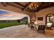 Covered patio with fireplace, seating area, and stunning sunset views at 10719 E Rimrock Dr, Scottsdale, AZ 85255