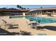 Community swimming pool with lounge chairs and a table with chairs at 7750 E Broadway Rd # 10, Mesa, AZ 85208