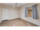 Simple bedroom with tile flooring, a window with curtains, and a door at 9985 E Legend Ct, Gold Canyon, AZ 85118