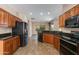 Modern kitchen with dark wood cabinets and black appliances at 9985 E Legend Ct, Gold Canyon, AZ 85118