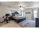Main bedroom with large bed, ceiling fan, and ensuite bathroom at 14760 W Riviera Dr, Surprise, AZ 85379