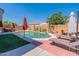 Inviting backyard oasis with a sparkling pool, lounge chairs, and patio umbrellas at 14760 W Riviera Dr, Surprise, AZ 85379