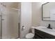 Bathroom with walk-in shower, white toilet and dark vanity at 14760 W Riviera Dr, Surprise, AZ 85379