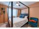 Relaxing bedroom with a four-poster bed and comfy chair at 14760 W Riviera Dr, Surprise, AZ 85379