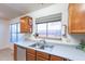 Kitchen with double sink, wood cabinets, and a window overlooking the backyard at 1023 E Escuda Dr, Phoenix, AZ 85024